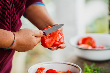 the cooking process for fresh vegetable salad,  healthy nutrition, women's hands cut cucumbers and tomatoes