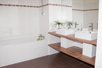 White and light wooden bathroom interior with a white tub, and a double sink