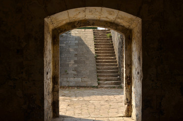 Door of an old fortress that frames a staircases
