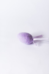 Violet easter egg on a stick on a white background