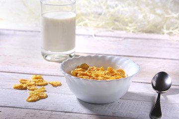 Corn Flakes cereal in a bowl and glass with milk. Morning breakfast.