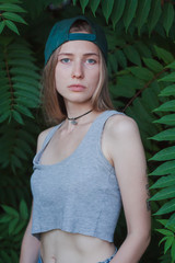 Portrait of beautiful young woman in green leaves, blonde pretty lady in spring bushes 