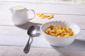 Corn Flakes cereal in a bowl and glass with milk. Morning breakfast.