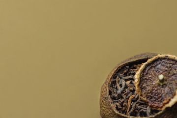 Aged Fermented Black Chinese Puer Tea in Tangerine Peel with Lid. Beige Background. Asian Cuisine Healthy Beverage.Close up. Copy Space. Banner Poster Streamer Template