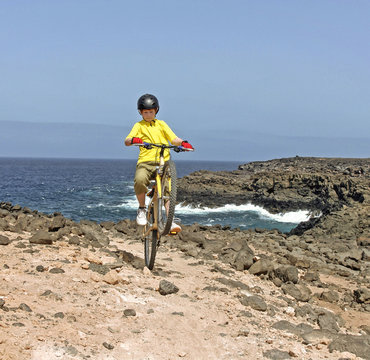 boy riding his mountain bike offroads  with wheely