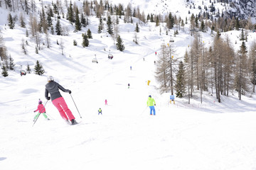 ski slope with skiers in the Alps