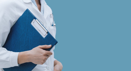 Professional female doctor posing with a clipboard