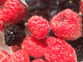 Background of different berries. Raspberries, blueberries and blackberries in the water.