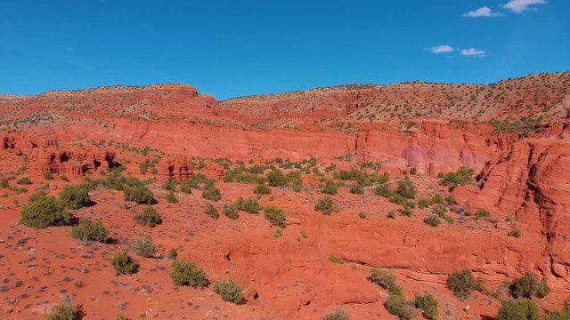 aerial shot flying over some beautiful red cliff formations in the desert