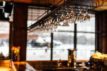 different glasses hanging over the bar. Soft focus