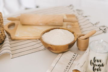 The process of preparing the dough on a wooden Board with sweet flour in the white kitchen, selective focus