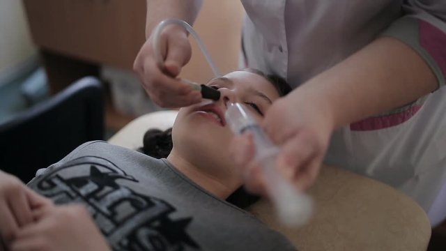 The treatment of sinusitis. Nasal rinses the girl with the help of the method of fluid displacement.