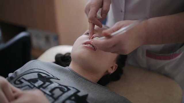 Nasal lavage method of transferring fluid. Washing the baby's nose in the clinic. The treatment of sinusitis.