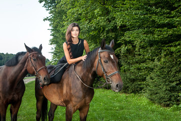 Pretty young woman riding a brown horse