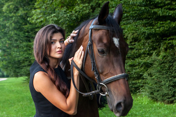 Pretty young woman and a brown horse