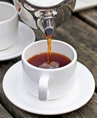 Pouring a cup of tea or coffee.