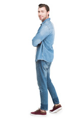 Fototapeta premium young smiling man in jeans looking at camera, isolated on white