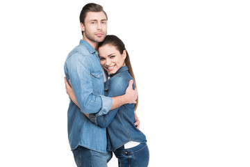 cheerful young couple embracing and looking at camera, isolated on white