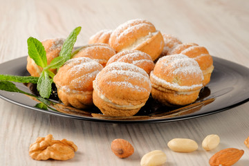 Sweet and delicious russian walnut cookies (filled with condensed milk) on the dark plate.