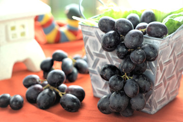 Black grapes. Close up and selective focus of bunch of black grapes hanging from container