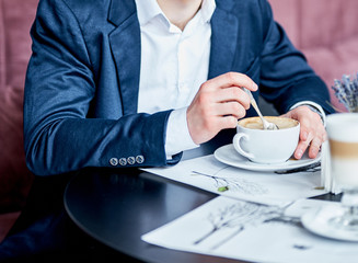 Business man in suit drinking coffee in cafe