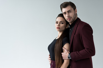handsome man hugging sensual woman, isolated on grey