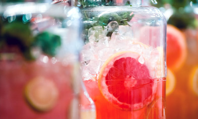 Orange juice with slince of grapefruit in jar on shelf, confectionery