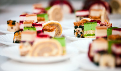 Many different types cakes on plates, confectionery