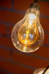 Beautiful yellow transparent garland lamps against a brick wall background