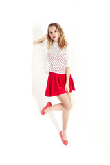 Isolated photo. The young girl with red lips and skirt on the white background