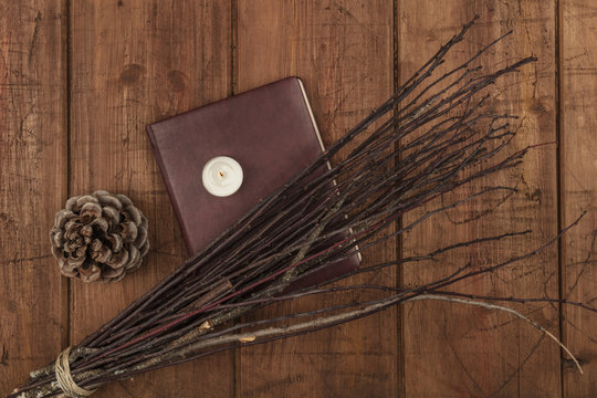 An Overhead Photo Of A Handmade Broom With A Book Of Shadows, A Candle, And Copy Space