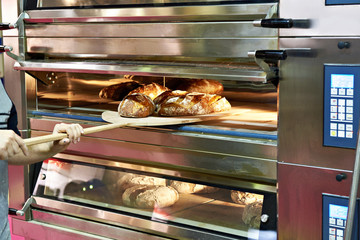 Man is baking bread in oven