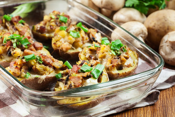 Baked potatoes in jacket stuffed with bacon, mushrooms and cheese. Dish served in baking dish..Baked potatoes stuffed with bacon, mushrooms and cheese