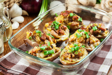 Baked potatoes in jacket stuffed with bacon, mushrooms and cheese. Dish served in baking dish..Baked potatoes stuffed with bacon, mushrooms and cheese