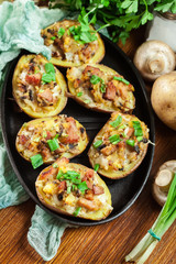 Baked potatoes in jacket stuffed with bacon, mushrooms and chees