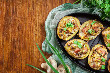 Baked potatoes in jacket stuffed with bacon, mushrooms and chees