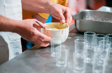 Confectioner preparing cream in pastry shop, food industry