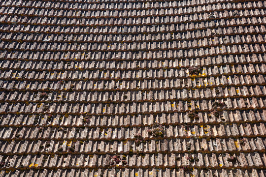 A large expanse of rustic French roof tiles, full frame construction background texture