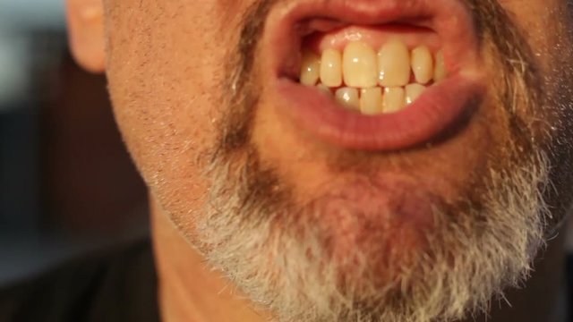 Open mouth of men with gray beard who screams and sings in front camera