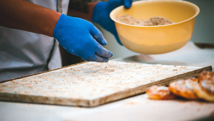 Confectioner preparing cookies on table in bakery, closeup