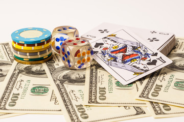 Poker chips and cards with american one hundred dollars bills on the white background.