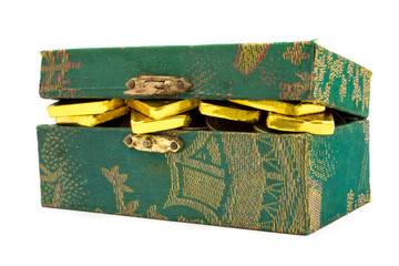 Pure gold bars and coins in green box on white background.