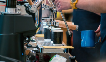 Barista preparing coffee using machine at coffee shop