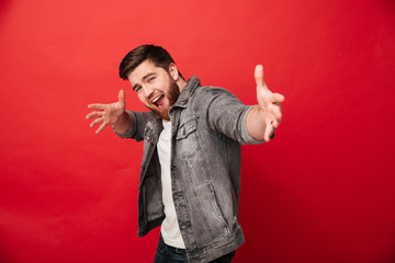 Photo of happy ecstatic guy 30s wearing beard in jeans jacket having fun and posing with open...