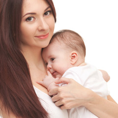 Obraz na płótnie Canvas Portrait of mother and her little child in white. Happy family concept. Mother holding cute baby isolated on white background. . Motherhood and children concept. Close up
