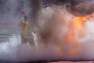 Firefighter in equipment extinguishes fire with a fire extinguisher