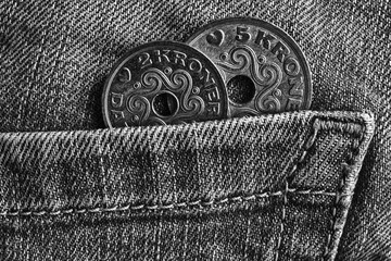 Denmark coins denomination is 5 and 2 krone (crown) in the pocket of old worn denim jeans, monochrome shot