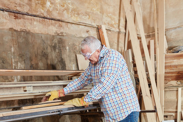 Senior arbeitet am Bandschleifer