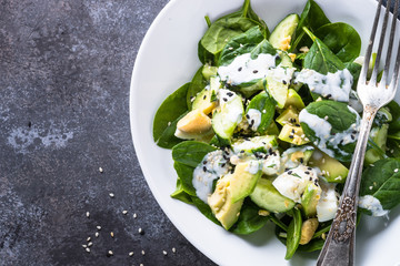 Green salad with avocado, spinach egg and cucumber.