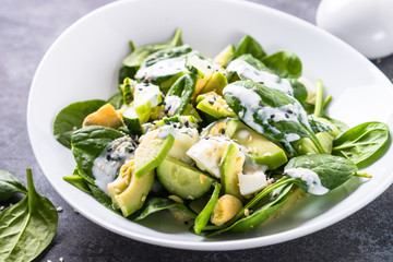 Green salad with avocado, spinach egg and cucumber.